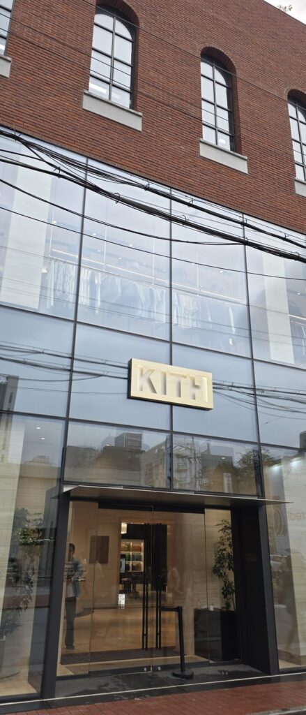 성수동 KITH 매장 외관, 오래된 벽돌 벽면과 새로 낸 대형 유리창이 대비를 이루고 전선이 화면을 가로지른다