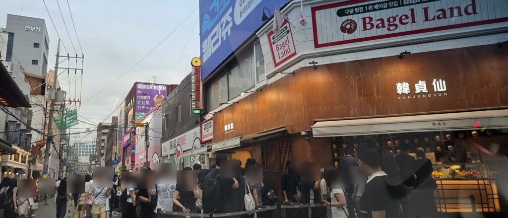 연무장길을 가득 메운 인파와 한국어 영어 중국어 일본어가 병기된 상점 간판들